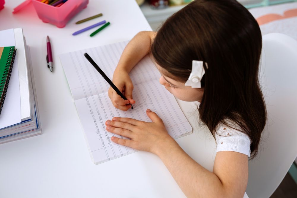 Girl doing homework sitting at a desk