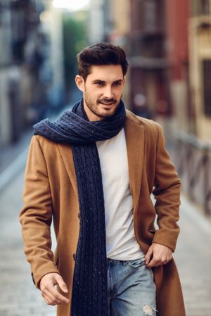 Handsome man in scarf walking down the street