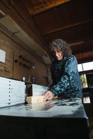 Mature man creating wooden detail in workshop