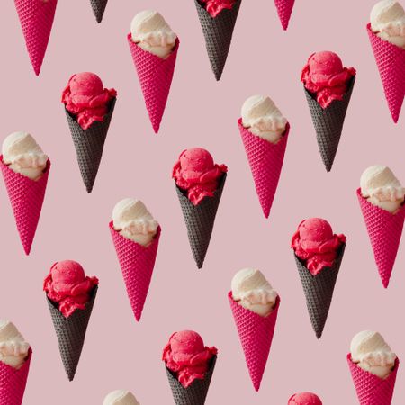 Pattern of vanilla and strawberry ice cream in waffle cones on pink background