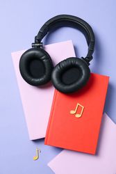 Concept of audiobook with books and headphones, top view