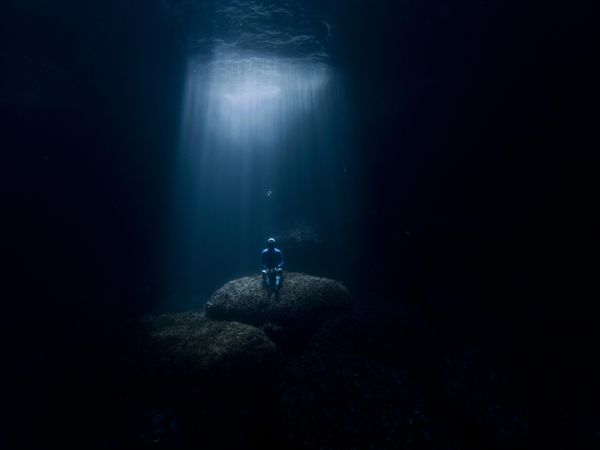 Person sitting on rock underwater