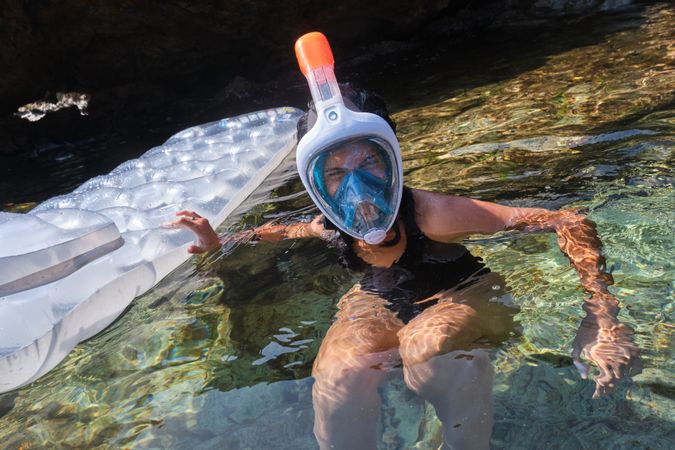 Woman in snorkeling mask swimming in sea