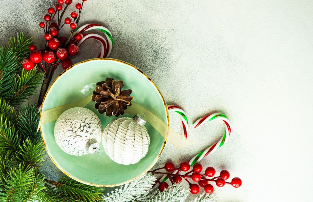 Top view of bauble ornament in green wintry plate with candy cane