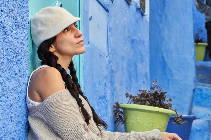 Pensive woman sitting on steps between ancient buildings