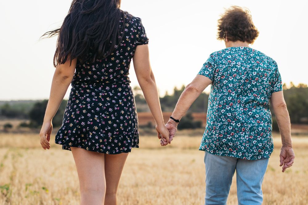 Two Generations Of Women Hold Hands: Grandmother And Granddaughter Holding Hands