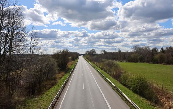 Empty highway crossing the countryside under a cloudy sky