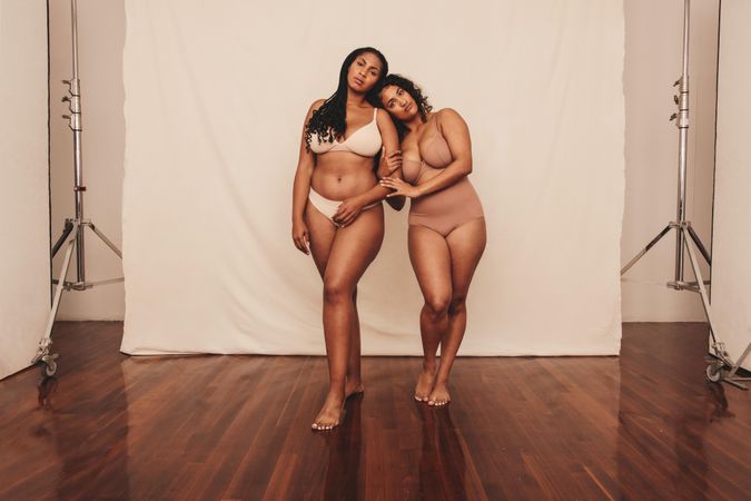 Full length of two women in neutral undergarments in studio