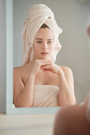 Calm woman in towel on head in bathroom