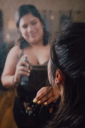 makeup artist using fixing spray for clients makeup