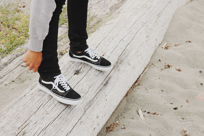 Cropped image of person wear dark sneakers standing outdoor