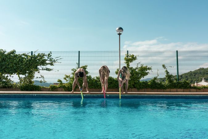 Friends playing with water pistols in the pool