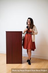 Woman giving a talk standing next to a podium 5qyKq5