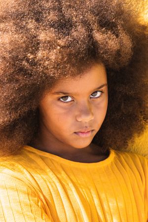 Black girl with Afro hairstyle looking at camera