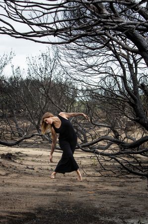 Woman dancing between dry trees
