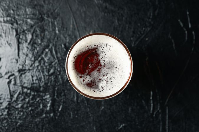 Glass of beer on background, top view
