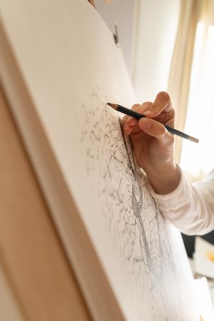 Person drawing city on canvas