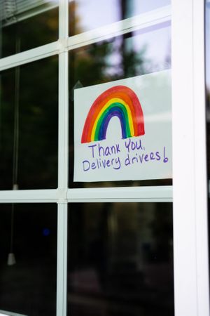 Close up of sign in-between window panes thanking delivery drivers during quarantine