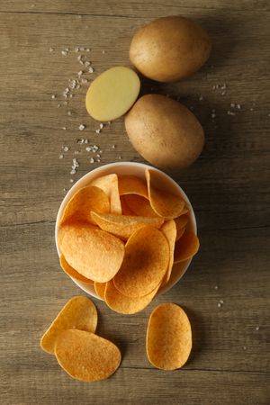 Potato chips in a bowl on a wooden background