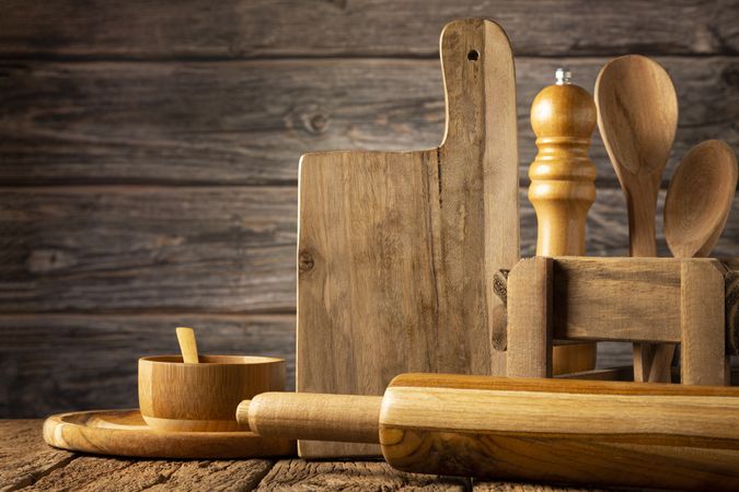 Wooden kitchen utensils on rustic background.