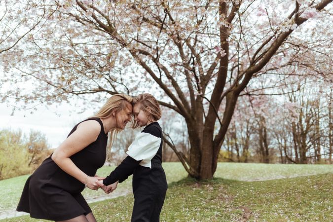 Mother and daughter standing under blooming tree