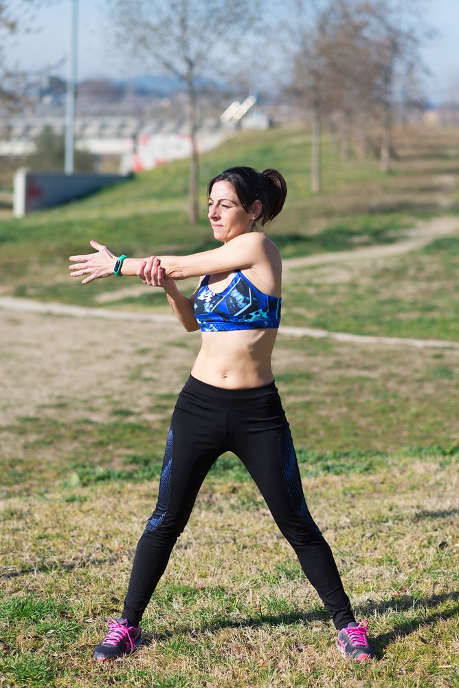 Woman stretching arms in park