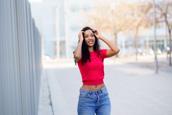 A Young Woman is Joyfully Posing Outdoors in a Casual and Trendy Outfit That Radiates Happiness