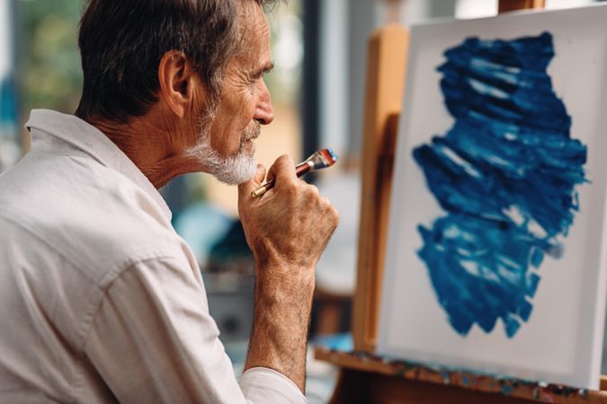 Male artist looking on canvas