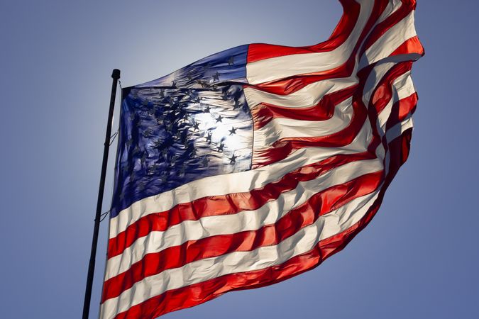 Dramatic Backlit American Flag Waving in the Wind.