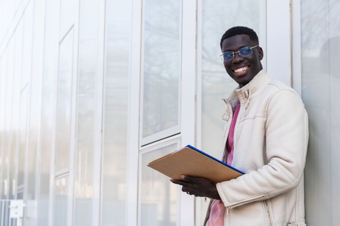 Black businessman with documents on clipboard in city