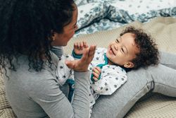 Mother playing peek-a-boo with toddler son