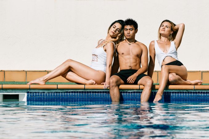 a group of young models by the pool in a summer day