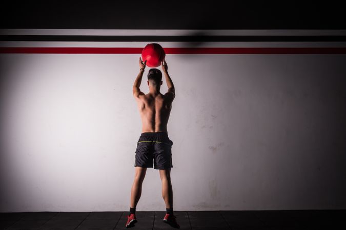 Man throwing ball on wall in gym