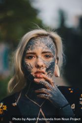 Edgy young blonde woman with cross-hatch facial tattoos and multiple piercings 0JGDp5