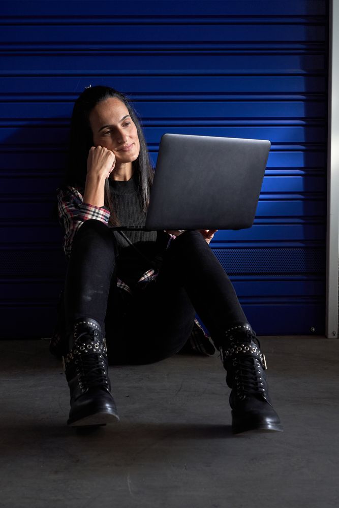 Woman browsing laptop near self storage