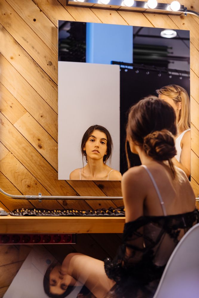 Serious brunette model looking in mirror