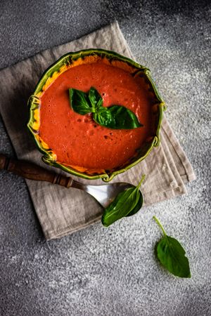 Top view of traditional tomato soup with herb garnish