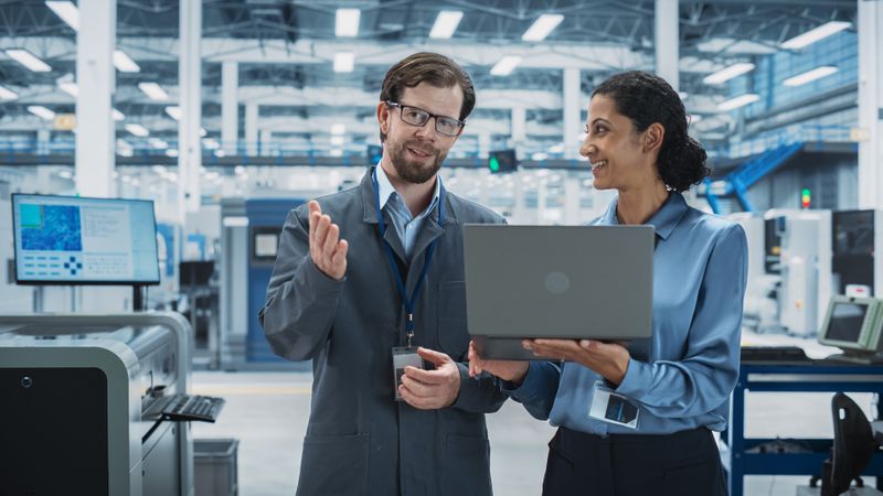 Colleagues talking in store with computer