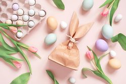 Top view of Easter eggs, tulips and paper bag in rabbit ear shapes