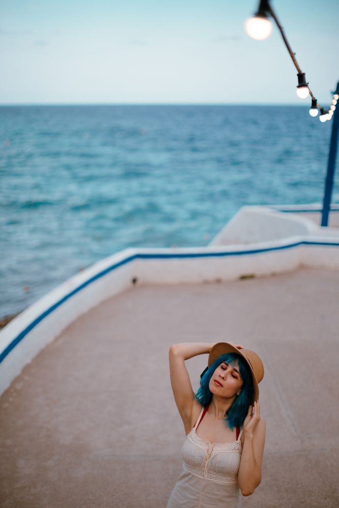 Charming woman in sundress walking along pier