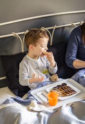 Mother and son having breakfast in bed