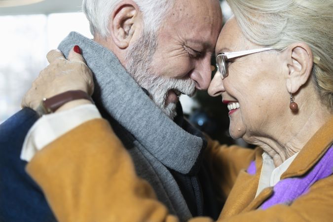 Mature couple smiling and pressing their faces together