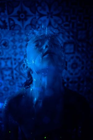 Child under water flow in shower room