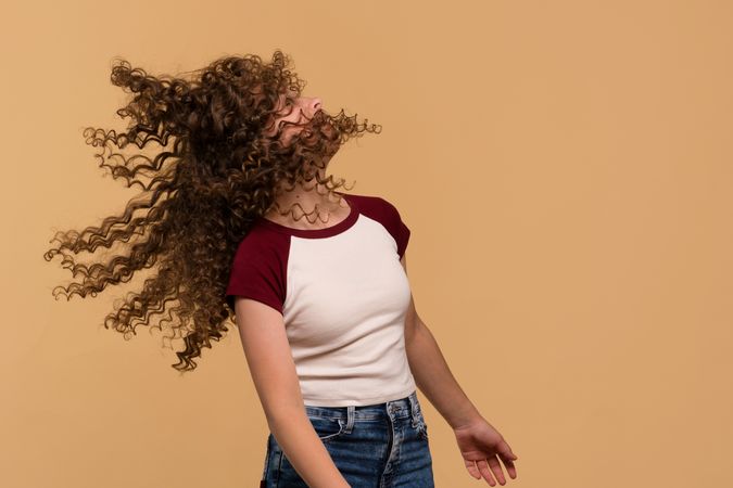 Young girl flipping hair energetically, showing movement and spontaneity