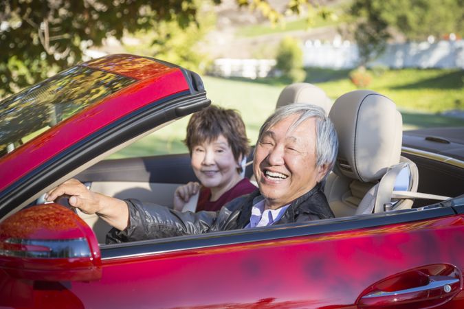 Happy Chinese Couple Enjoying An Afternoon Drive in Their Convertible