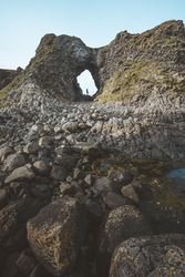 Woman standing inside rocky cave
