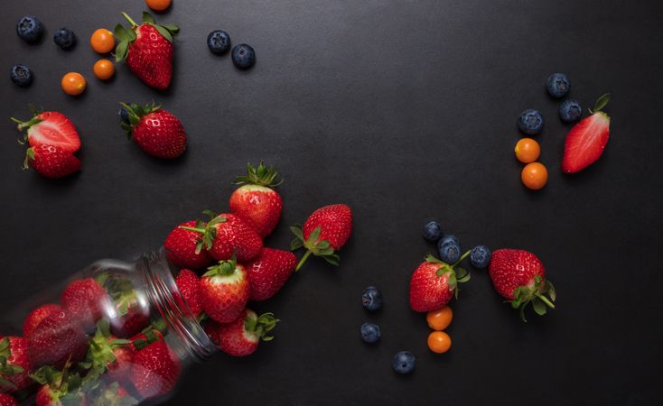Fresh strawberries and blueberries on dark background