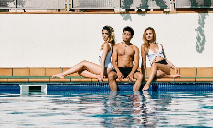 a group of young models by the pool in a summer day