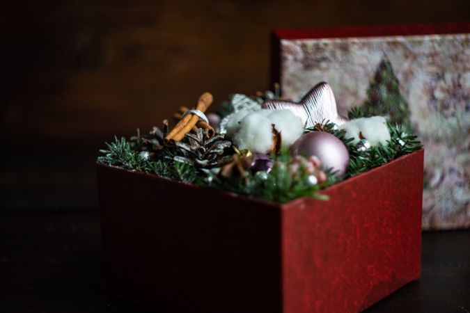 Box of Christmas decorations with baubles, fir tree and cotton heads