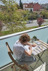Kid painting on balcony of house